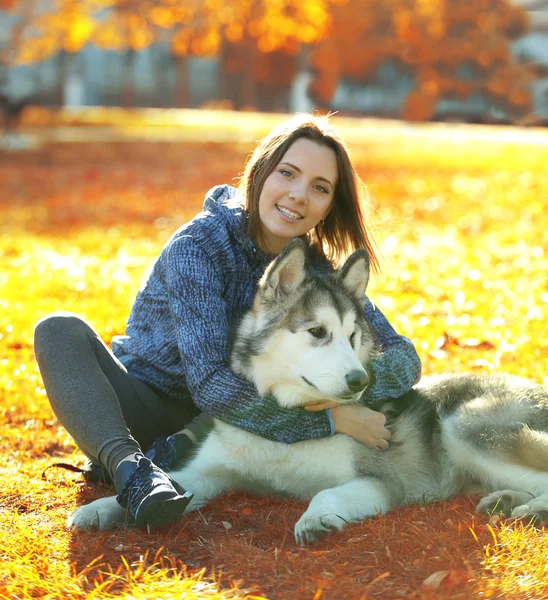 Vrouw zitten met haar hond in park — Stockfoto