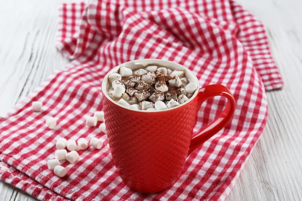 Una taza de sabroso cacao y malvavisco sobre fondo de servilleta a cuadros —  Fotos de Stock