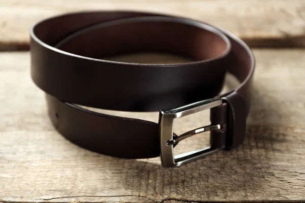 Leather belt with buckle on wooden background — Stock Photo, Image