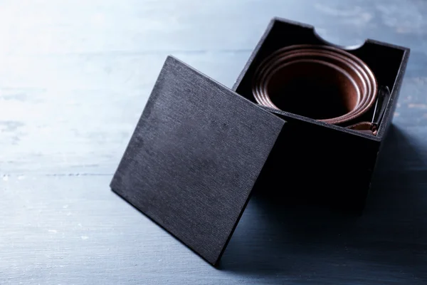 Кожаный пояс с пряжкой в подарочной коробке на деревянном фоне — стоковое фото