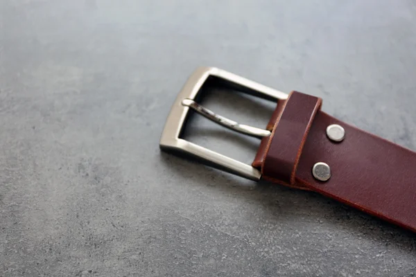 Cinturón de cuero con hebilla sobre fondo gris —  Fotos de Stock