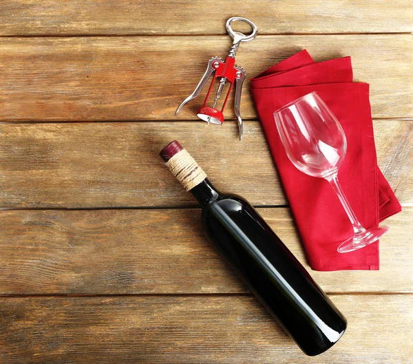 Bottle of wine with glass and corkscrew on wooden background — Stock Photo, Image