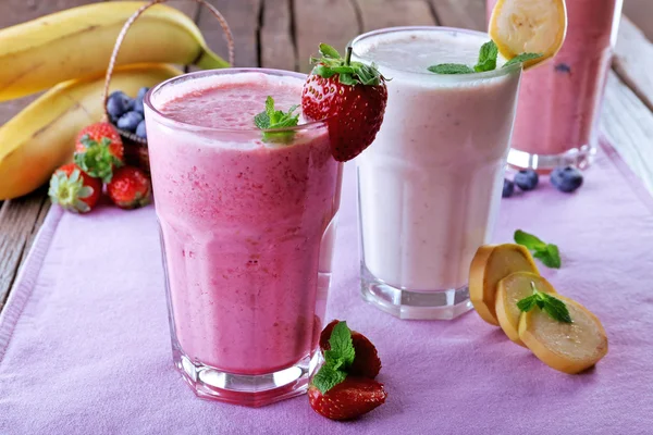 Vasos de batido frío fresco con frutas y bayas, sobre la mesa, primer plano —  Fotos de Stock