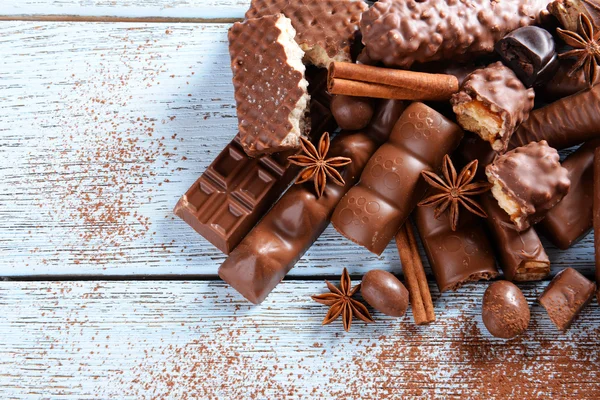 Doces de chocolate com pó sobre fundo de madeira — Fotografia de Stock