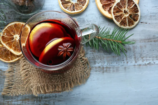 Smakelijke glühwein en specerijen, op blauwe houten achtergrond, close-up — Stockfoto