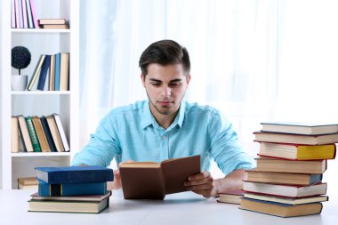 Genç adam kitap okuyor.