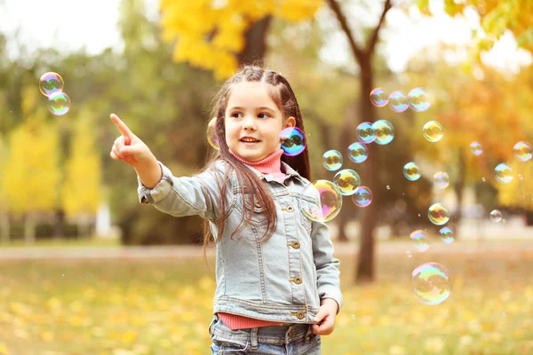 Girl blowing soap bubbles — Stock Photo, Image