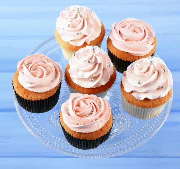 Smakelijke cupcakes op een houten achtergrond kleur — Stockfoto
