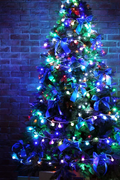Kerstboom op bakstenen muur achtergrond — Stockfoto