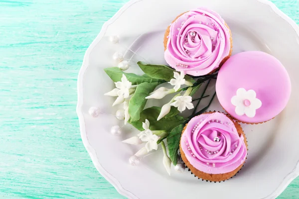 God cupcakes på plattan, färg trä bakgrund — Stockfoto