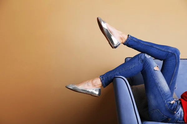 Pernas de mulher no sofá com sapatos elegantes — Fotografia de Stock