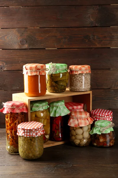 Pots avec légumes marinés et haricots sur fond en bois — Photo