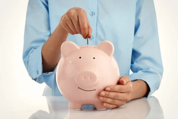 Putting coin into piggy bank — Stock Photo, Image