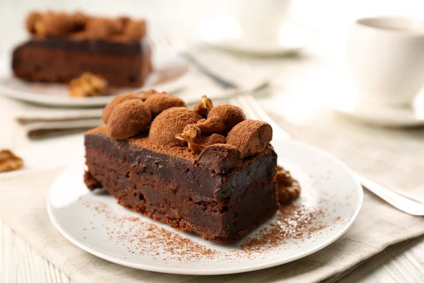 Bit av chokladkaka med valnöt på bordet, närbild — Stockfoto