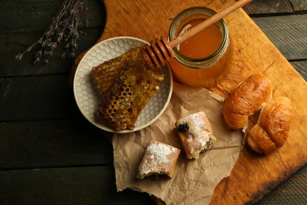 Honungskakor på plattan, hot kaffebröd på trä bakgrund — Stockfoto