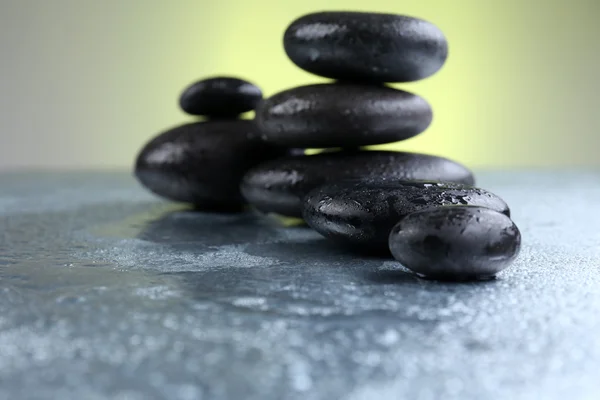 Black pebbles on grey table, close up — Stock Photo, Image