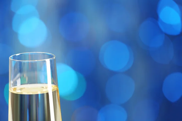 Een glas champagne op blauwe onscherpe achtergrond — Stockfoto