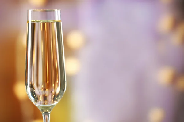 A glass of champagne on blurred lighted background — Stock Photo, Image