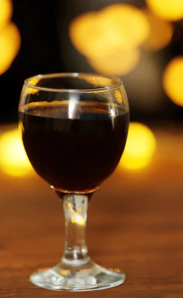 Ein Glas Rotwein auf unscharf beleuchtetem Hintergrund — Stockfoto