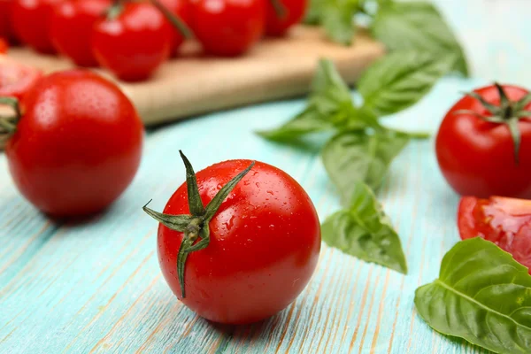 Tomates frescos con albahaca sobre mesa de madera de cerca — Foto de Stock