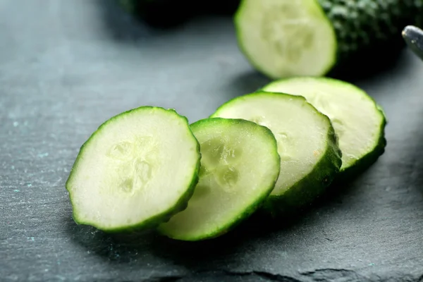 Sliced cucumbers on black background, close up — Stock Photo, Image