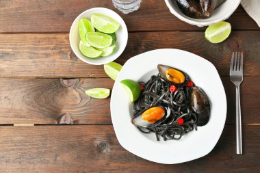 Makarna, midye ve kireç kahverengi ahşap zemin üzerine pişmiş