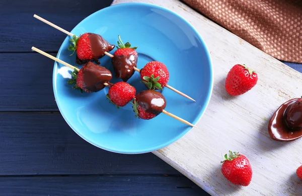 Läckra jordgubbar i choklad på köksbord — Stockfoto