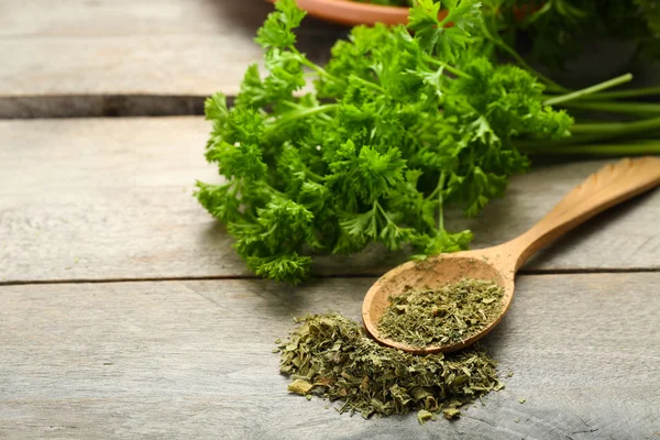 Fresh and dried parsley on wooden background — Stock Photo, Image
