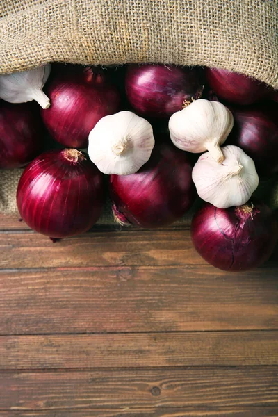 Sacchetto sparso con cipolle rosse e aglio — Foto Stock