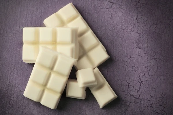 Witte chocolade stukjes op een houten achtergrond kleur — Stockfoto