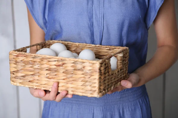 Huevos en cesta en manos de mujeres —  Fotos de Stock