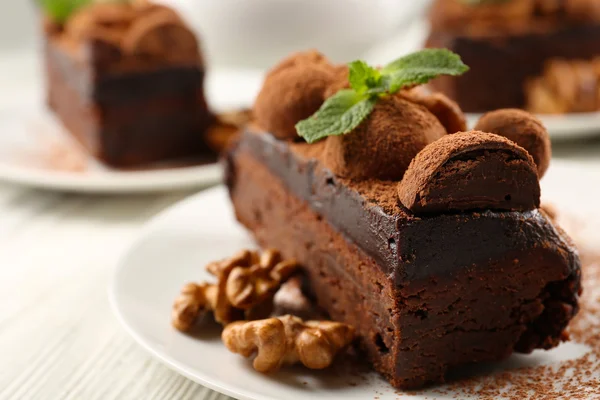 Stück Schokoladenkuchen mit Walnuss und Minze auf dem Tisch, Nahaufnahme — Stockfoto