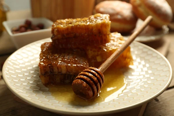 Honungskakor på plattan på trä bakgrund — Stockfoto