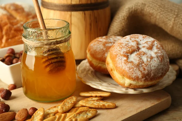 Vaso di vetro con miele, favi e noci su fondo di legno — Foto Stock