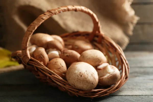 Cogumelos em cesta na superfície de madeira — Fotografia de Stock