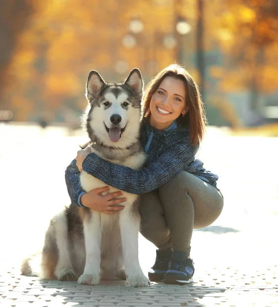 Kvinna promenader med hund i parken — Stockfoto