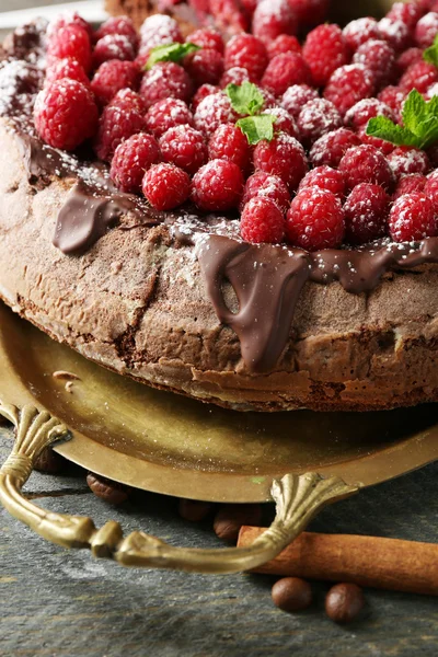 Kuchen mit Schokoglasur und Himbeeren auf Holzgrund — Stockfoto