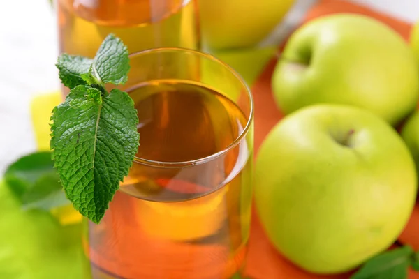 Bicchieri di succo di mela con frutta e menta fresca sul tavolo da vicino — Foto Stock