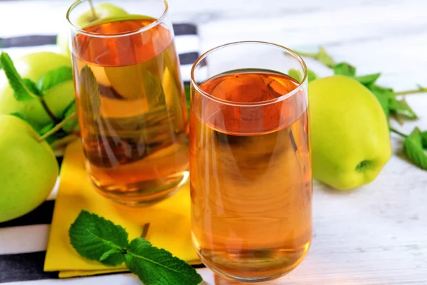 Copos de suco de maçã com frutas e hortelã fresca na mesa de perto — Fotografia de Stock