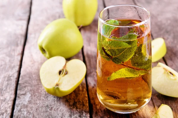 Glas äppeljuice med frukt och färsk mynta på bordet på nära håll — Stockfoto