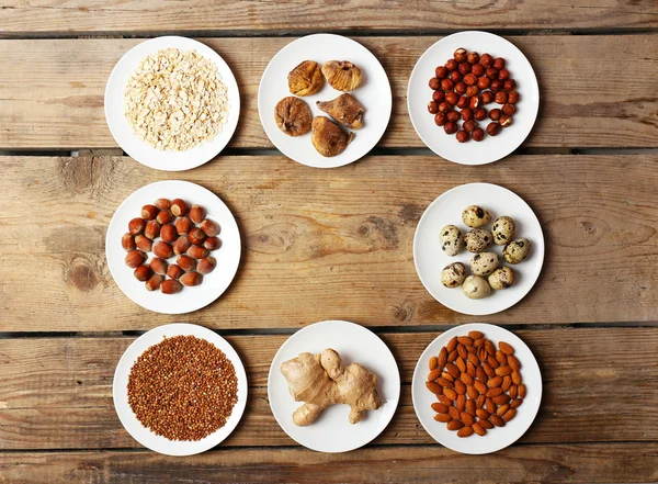 Different products on saucers on wooden table, top view — Stock Photo, Image