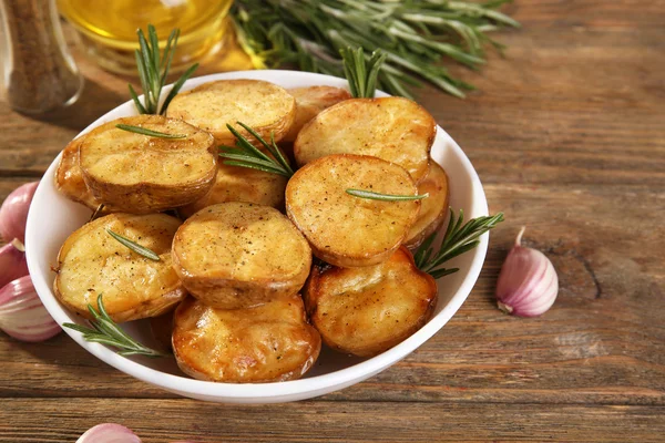 Deliziosa patata al forno con rosmarino in ciotola sul tavolo da vicino — Foto Stock