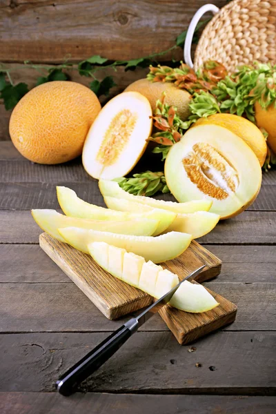 Rijpe meloenen met groene bladeren op tafel close-up — Stockfoto