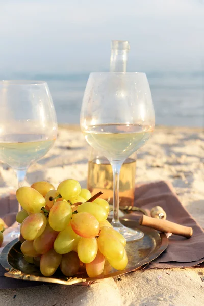 Composition romantique de vin blanc et de raisin sur une plage de sable — Photo