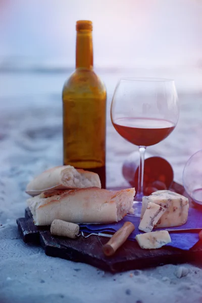 Hermosa composición romántica de vino tinto, pan y nueces en la playa de arena, de cerca — Foto de Stock