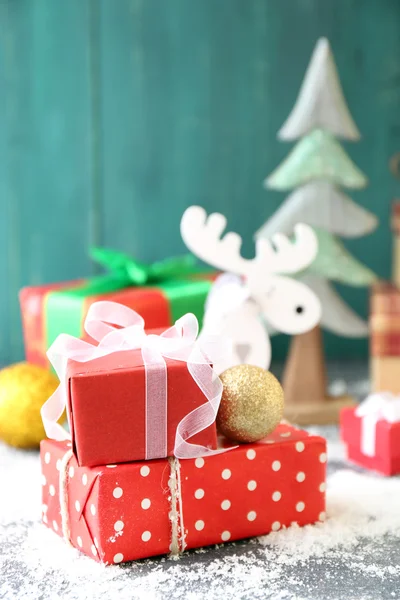 Weihnachtsgeschenke auf farbigem Holzhintergrund — Stockfoto