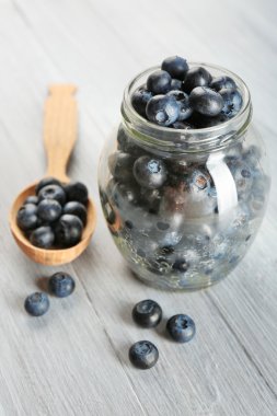 Kaşık ve kavanoz ahşap masa üzerinde taze yaban mersini yakın çekim