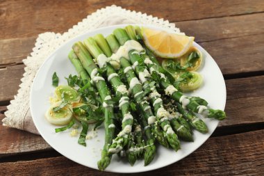 Ekşi krema sos soğan, peynir ve limon ahşap arka plan beyaz tabakta iştah açıcı kuşkonmaz