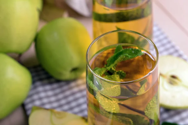 Bicchieri di succo di mela con frutta e menta fresca sul tavolo da vicino — Foto Stock