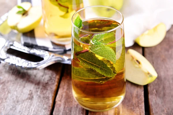 Bicchieri di succo di mela con frutta e menta fresca sul tavolo da vicino — Foto Stock